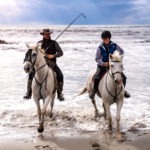 cowboy with Camargue horse on beach on France riding holiday by globetrotting
