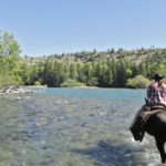 rider crossing river horse riding holiday canada by globetrotting